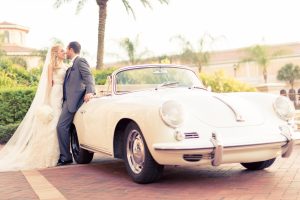Newlyweds standing in front of car at Rosen Shingle Creek
