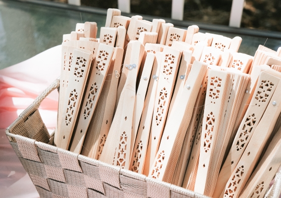 A basket of closed wooden fans sitting on a table.