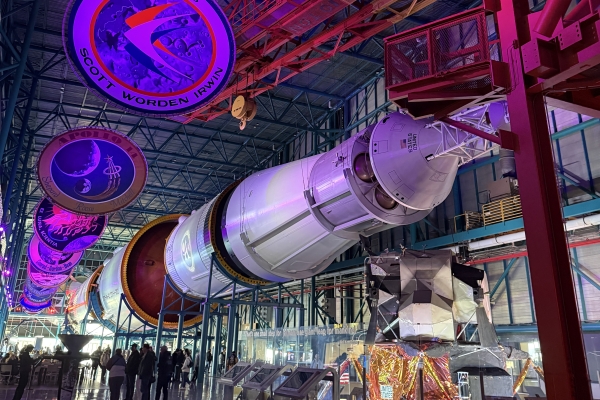 A large piece of space ship suspended from the ceiling in an exhibit at Kennedy Space Center. 