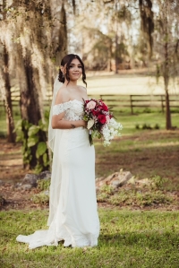 Bride wearing a mermaid style wedding dress holding a bouquet of flowers.