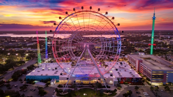 The Orlando Eye observation wheel towering over ICON Park at sunset.