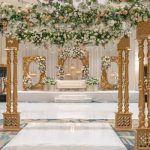 Ornate golden pillars and arches covered in greenery and flowers for an indoor garden feeling.