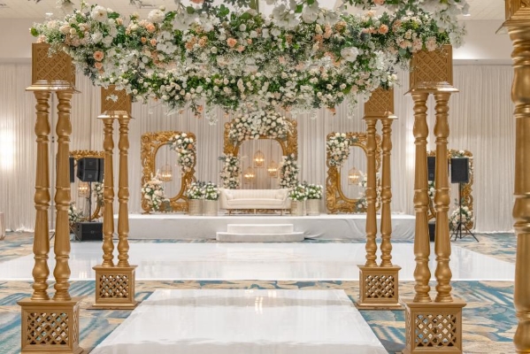 Ornate golden pillars and arches covered in greenery and flowers for an indoor garden feeling.