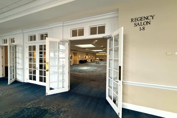 Open white French doors lead into a long hallway labeled as the Regency Salon at Rosen Plaza.