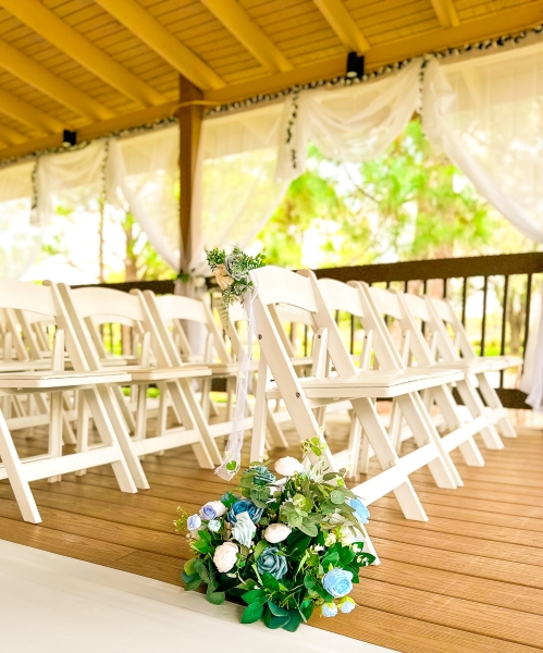Rows of white chairs at an outdoor wedding ceremony venue in Orlando.
