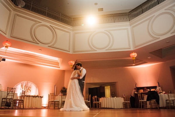A bride and groom embrace on an empty dance floor in a two-story venue, The Butler Ballroom, at Rosen Shingle Creek.