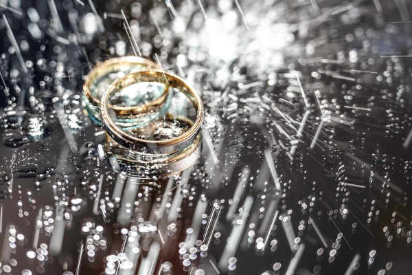 Two stacked wedding rings in the rain.