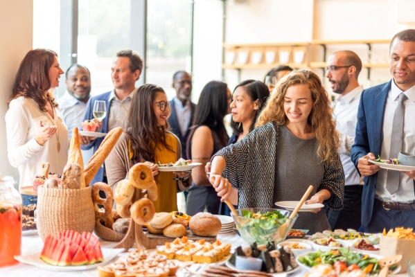 A group of people mingling and helping themselves at a morning brunch.