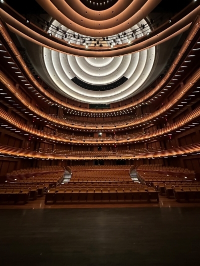 The view from onstage looking out over hundreds of audience seats and glowing balconies.  