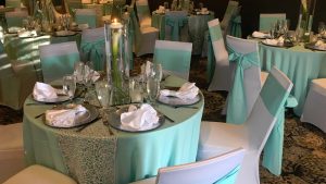 Wedding Reception Tables with White Chairs and Turquoise Table Cloth
