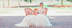 Bride sitting outside on couch holding flowerrs