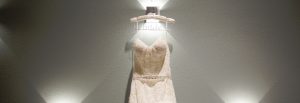 Wedding dress hanging on wall surrounded by lights