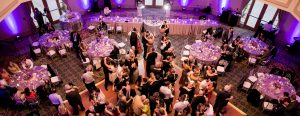 Wedding guests dancing at reciption under purple lights