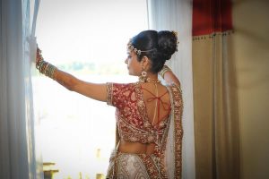 Indian bride standing in front of window looking out