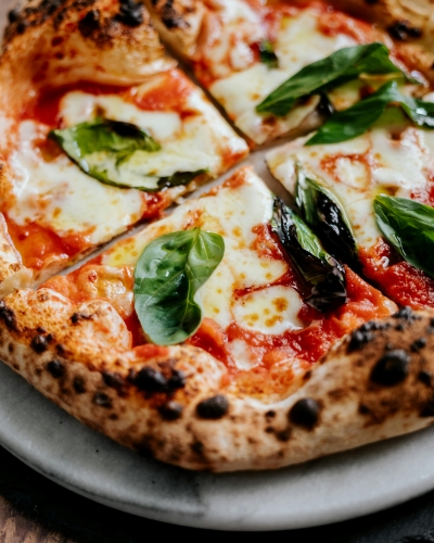 A close-up of pizza with basil on top.