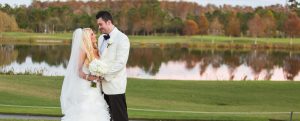 Newlyweds outside infront of lake at Rosen Shingle Creek